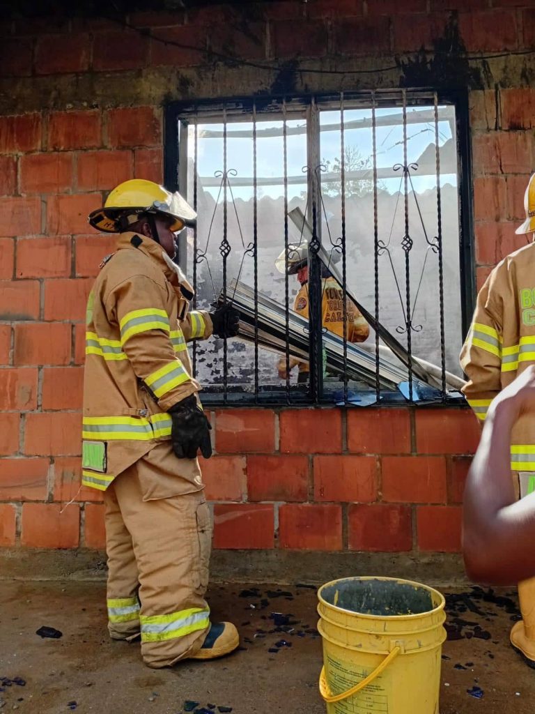Bombero inspecciona el interior de la vivienda después del incendio.