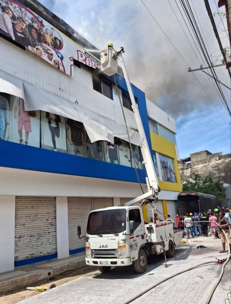 Unidades bomberiles realizan labores de atención de la emergencia con apoyo de un vehículo especializado.