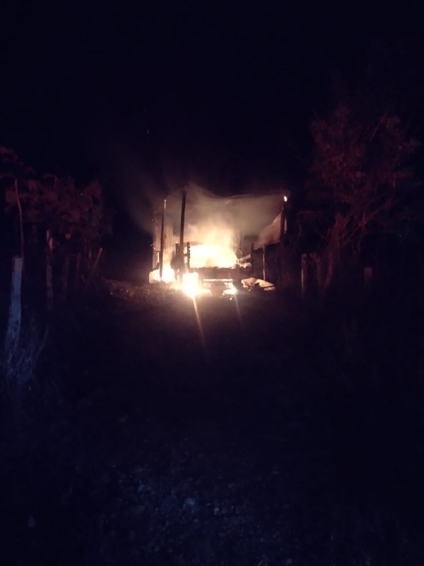 Vista nocturna del incendio que consumió una camioneta y el garaje donde se encontraba.