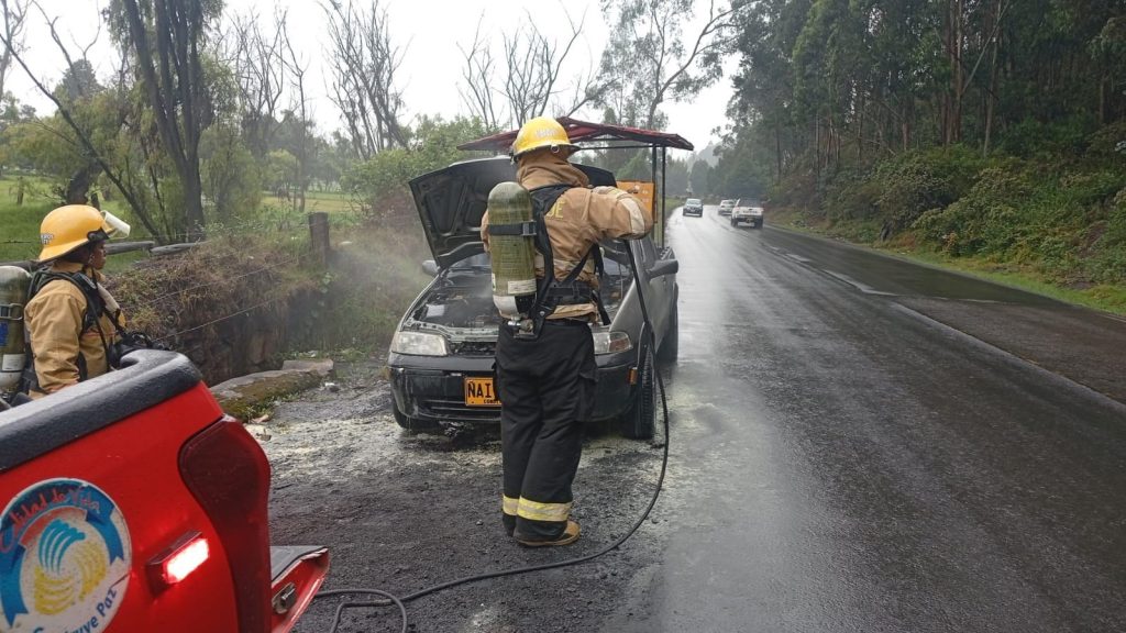Bomberos en apoyando extinguir incendio Vehicular